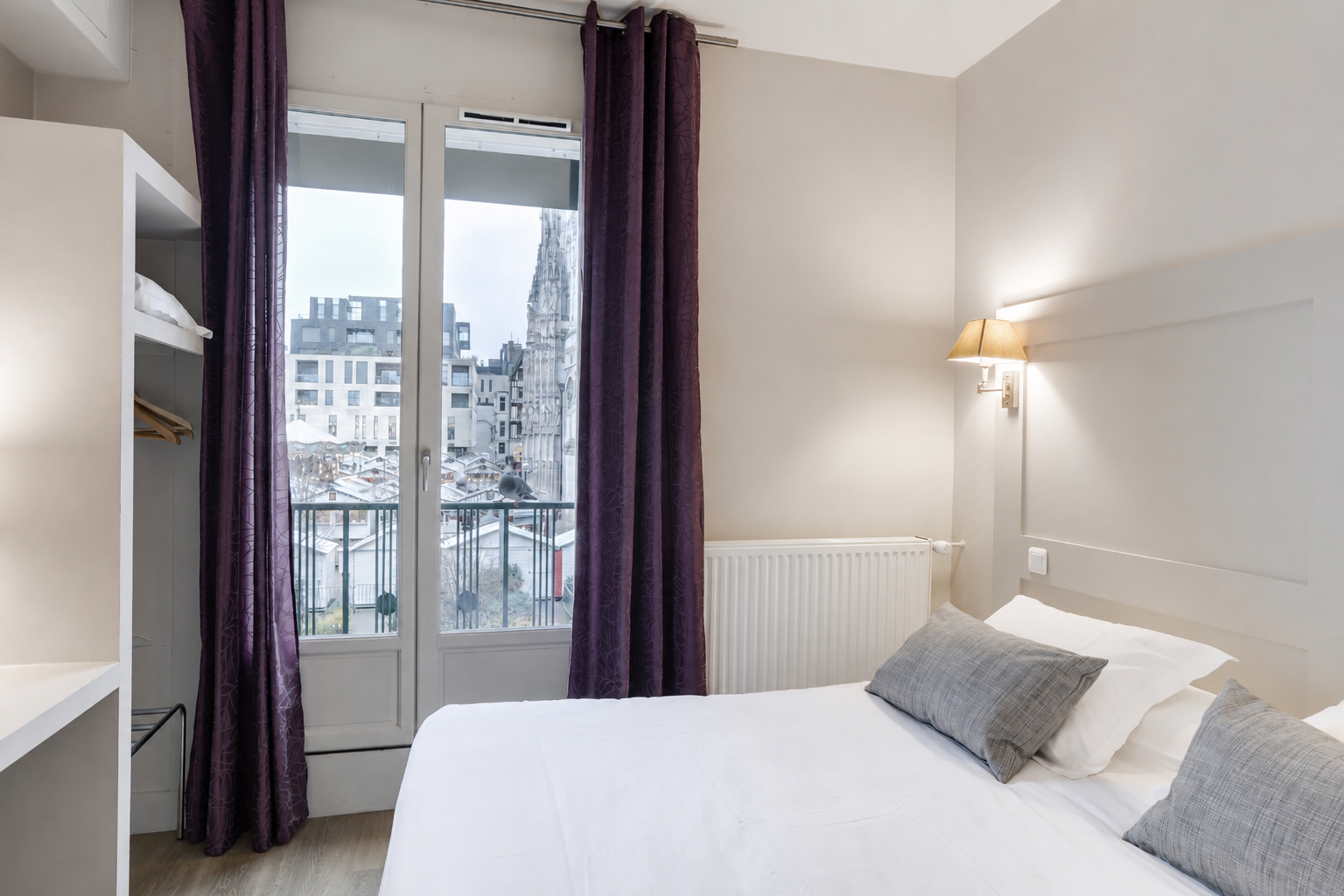 Chambre double avec rideaux violets et vue sur la cathédrale de Rouen