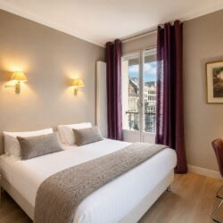 Chambre supérieure de l’Hôtel Cardinal Rouen avec lit double, bureau et vue sur la cathédrale